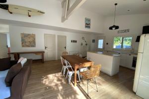 uma cozinha e sala de estar com uma mesa e um sofá em VILLA DES BECASSES - Andernos les Bains em Andernos-les-Bains