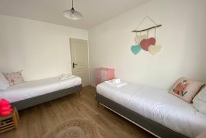 um quarto com duas camas com corações na parede em VILLA DES BECASSES - Andernos les Bains em Andernos-les-Bains