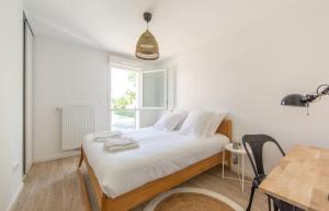 una camera con letto, tavolo e finestra di APPARTEMENT Des Verdiers a Andernos-les-Bains