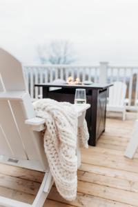 una coperta seduta su una sedia accanto a un tavolo di Lakeview Luxury Farmhouse Retreat - Hot Tub - Games Room a Cobourg
