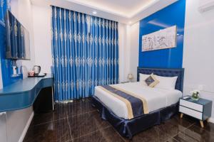 ARINA HOTEL في Tây Ninh: غرفة زرقاء مع سرير وجدار ازرق