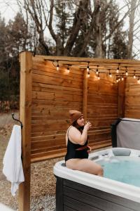 una donna seduta in una vasca idromassaggio di Lakeview Luxury Farmhouse Retreat - Hot Tub - Games Room a Cobourg