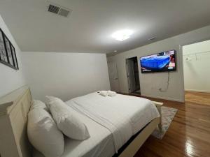 a bedroom with a bed and a flat screen tv at NEwark Airport Elegant 3 Kings APT in Elizabeth