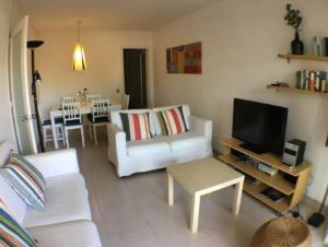 ein Wohnzimmer mit einem weißen Sofa und einem TV in der Unterkunft Apartamento en Vilanova in Vilanova i la Geltrú