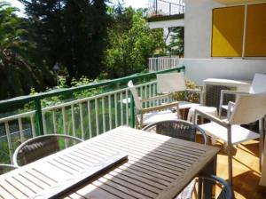 eine Außenterrasse mit Stühlen, Tischen und einem Geländer in der Unterkunft Apartamento en Vilanova in Vilanova i la Geltrú