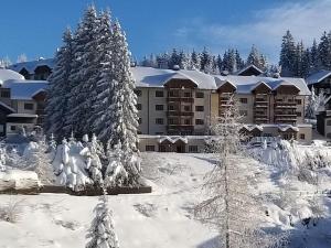 a resort with snow covered trees and a building at Atemberaubende Aussicht, direkter Pistenzugang in Deutschberg