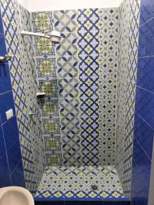 La salle de bains est revêtue de carrelage bleu et blanc. dans l'établissement Lienzo Hostel and Mural Art Museum, à Popayan