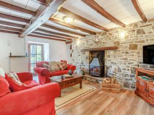 a living room with red furniture and a stone fireplace at 2 Bed in Penycae 89170 in Pen-y-cae