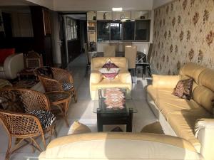 Sealink view Apartment next to Hinduja Hospital في مومباي: غرفة معيشة بها كنب وكراسي وطاولة