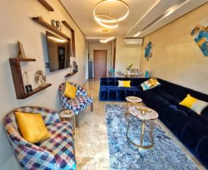 - un salon avec un canapé bleu et des chaises dans l'établissement Appartement de Luxe Prestigia, à Marrakech