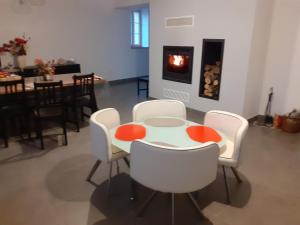 a table and chairs in a living room with a fireplace at Gîte les Pyrénéales dans le madiranais in Lascazères