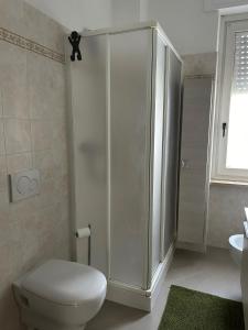 La salle de bains blanche est pourvue d'une douche et de toilettes. dans l'établissement MiLu's house - CIR 0092 -, à Sarre