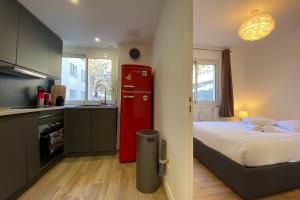 uma cozinha com uma cama e um frigorífico vermelho em 06BD - Nice 6-person apartment facing the slopes em Péone