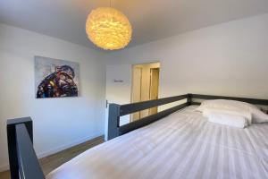 um quarto com uma cama e um lustre em 06BD - Nice 6-person apartment facing the slopes em Péone