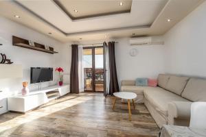 a living room with a couch and a tv at Melani in Mošćenička Draga