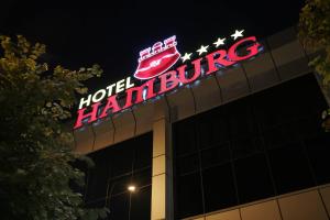 un panneau néon au sommet d'un bâtiment dans l'établissement Hotel Hamburg, à Skopje