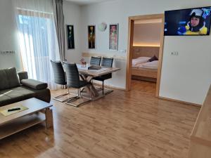 uma sala de estar com uma mesa e cadeiras e um quarto em Residence Klementhof em Naz-Sciaves