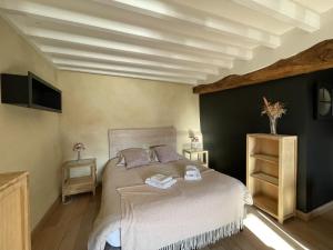 a bedroom with a bed with a white bedspread at Le P'tit Louis in Saint-Cyr-les-Colons
