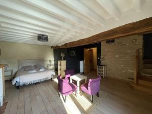 - une chambre avec un lit et des chaises violettes dans l'établissement Le P'tit Louis, à Saint-Cyr-les-Colons