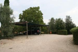 ein Auto, das unter einem Baldachin in einer Einfahrt geparkt ist in der Unterkunft Agriturismo I Fuochi in Valiano