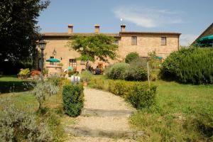 a stone house with a garden in front of it at Agriturismo I Fuochi in Valiano