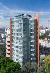 un grand bâtiment en verre au milieu d'une ville dans l'établissement Amazing Estudio with Terrace and Restaurant, à Mexico