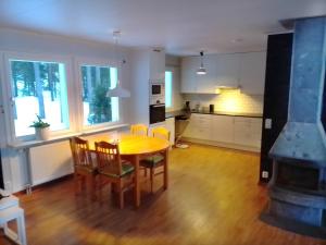 cocina y comedor con mesa y sillas en Havsnära villa en Nordmaling