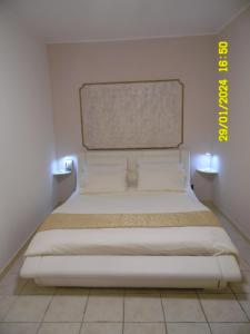 a bed in a room with two lights on the wall at La Casa di Giuditta - B&B Casa Vacanze - Ramacca in Ramacca