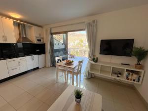 a kitchen and dining room with a table and a television at COSTA AZUL APARTMENTS - 2A in Puerto de Mogán