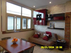ein Wohnzimmer mit einem Sofa und einem Tisch in der Unterkunft La Casa di Giuditta - B&B Casa Vacanze - Ramacca in Ramacca
