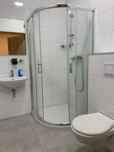 a bathroom with a shower and a toilet and a sink at Ząbkowickie Centrum Sportu i Rekreacji Sp. z o. o. in Ząbkowice Śląskie