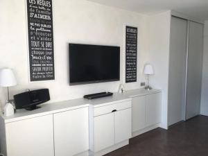 a white cabinet with a television on a wall at Appartement Huez, 1 pièce, 4 personnes - FR-1-405-228 in LʼHuez