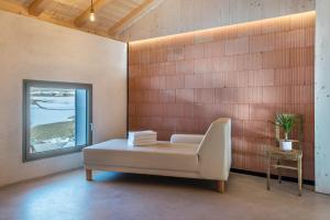 ein weißes Sofa in einem Zimmer mit Fenster in der Unterkunft Lena Dolomites Luxury Suite in Villnöß