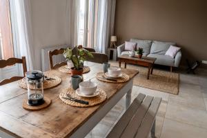 una sala de estar con una mesa de madera con platos. en Les 3 Monts - vue panoramique sur les montagnes en Annecy