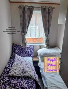 um pequeno quarto com 2 camas e uma janela em Inviting beautiful 3-Bed Caravan in Ingoldmells em Ingoldmells