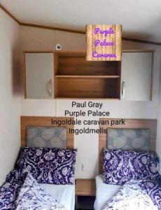 um quarto com duas camas e uma placa na parede em Inviting beautiful 3-Bed Caravan in Ingoldmells em Ingoldmells