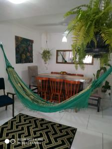 a hammock in a living room with a table and chairs at Casa em Balneário Camboriú - próxima à praia in Balneário Camboriú