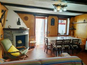 a living room with a table and chairs and a fireplace at Appartamento CHAMPORCHER in Champorcher