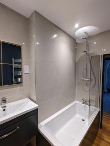 La salle de bains est pourvue d'une baignoire, d'un lavabo et d'une douche. dans l'établissement Salt Life Belgravia Apartment, à Brighton et Hove