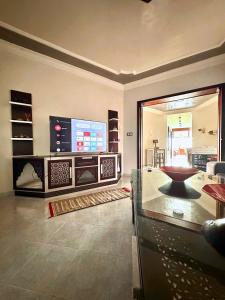 un salon avec une grande télévision et une table dans l'établissement Le Traditionnel - 3BR Panoramic SeaView Retreat on the Corniche, à Tanger