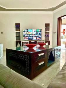- un salon avec une table et une télévision dans l'établissement Le Traditionnel - 3BR Panoramic SeaView Retreat on the Corniche, à Tanger