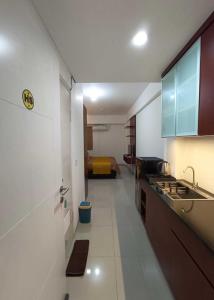 eine Küche mit einem Waschbecken und ein Bett in einem Zimmer in der Unterkunft Hariss Inn Bandara in Teko