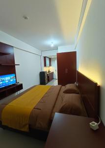 a bedroom with a large bed with a yellow blanket at Hariss Inn Bandara in Teko