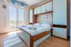 a bedroom with a bed and a large window at Apartments Ljiljana in Supetarska Draga +75 photos