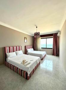 - une chambre avec 2 lits et une grande fenêtre dans l'établissement Le Traditionnel - 3BR Panoramic SeaView Retreat on the Corniche, à Tanger