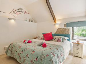 a bedroom with two beds with red pillows at 3 Bed in Lanhydrock 90217 in Bodmin