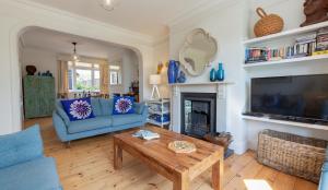 a living room with a blue couch and a table at Thalassa in Walberswick