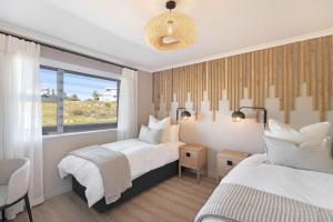 een slaapkamer met 2 bedden en een raam bij Coral Island 204 in Bloubergstrand
