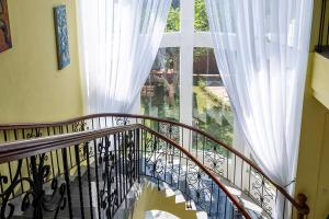 Private Urban Villa Denpasar في دينباسار: درج يؤدي إلى نافذة كبيرة مع ستائر بيضاء