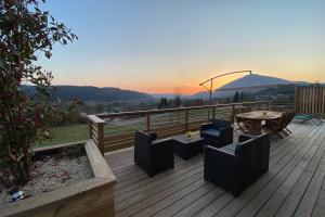 eine Terrasse mit einem Tisch, Stühlen und einem Sonnenschirm in der Unterkunft Gîte dans les Vosges Gite du Feing des Loges in Vagney